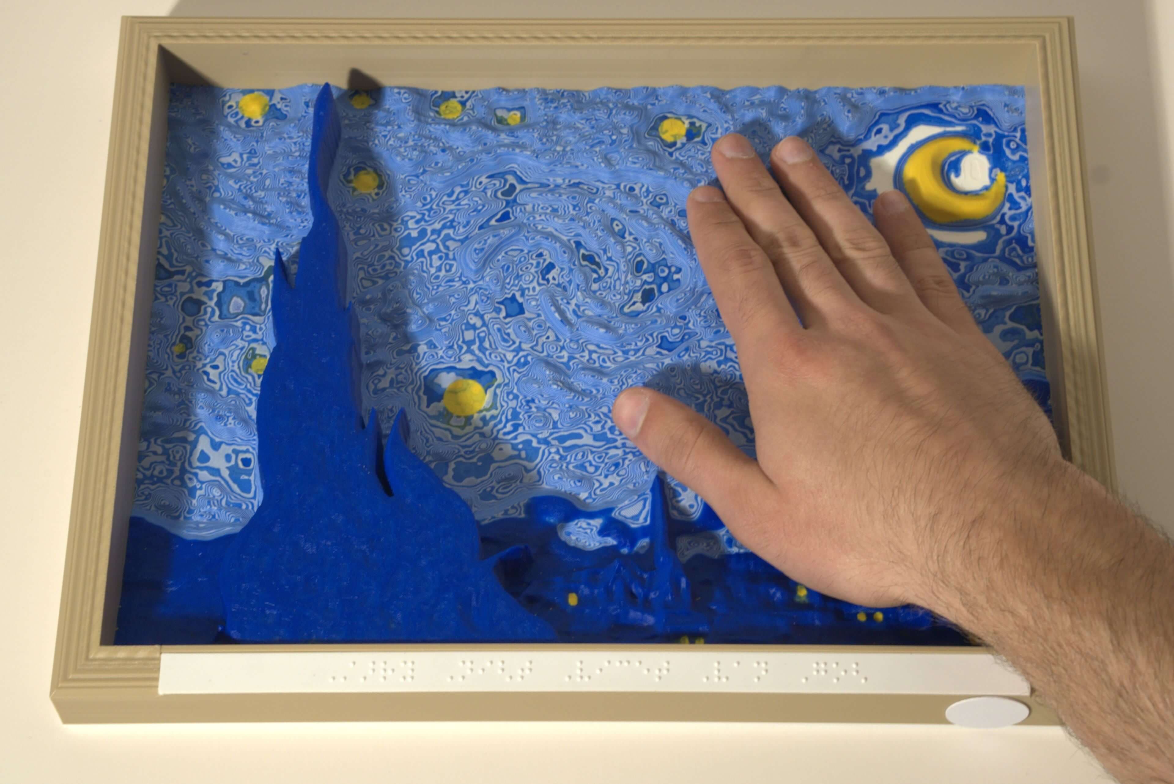 Hand touching a tactile contour canvas of Starry Night